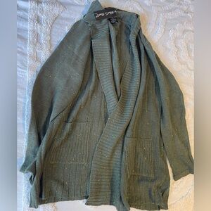3X What’s next green sweater with little colored stitching all over it.